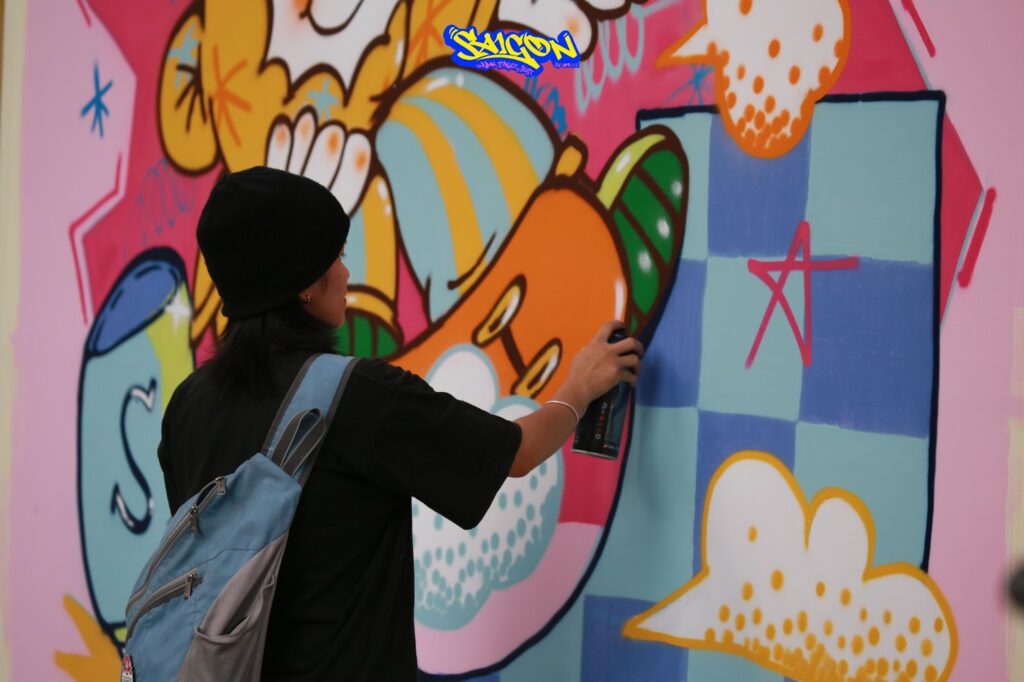 Artist Thao Xeko putting the finishing touches on the “Saigon Fun” mural