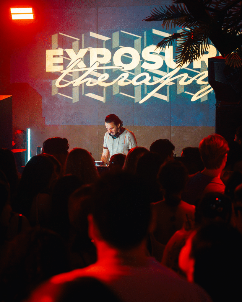 A DJ energizes the audience, filling the hall with lively music